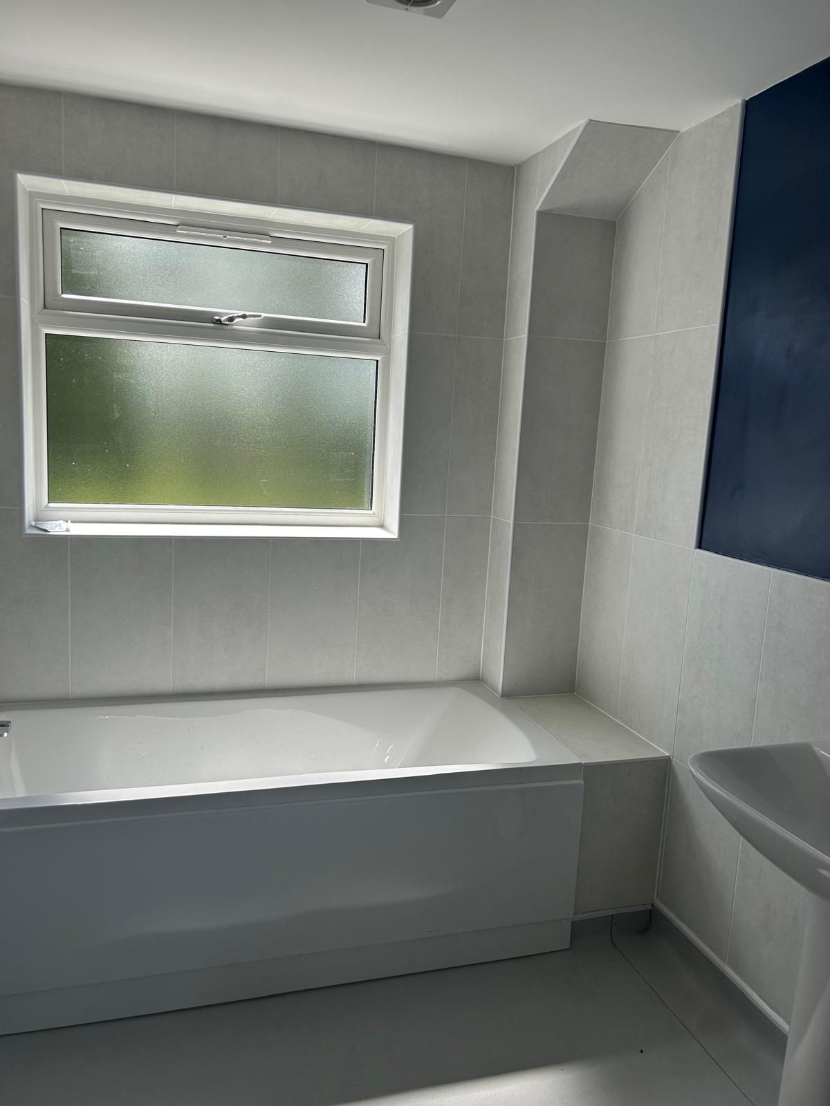 Tiled bathroom with bath and basin after a clean by Maid in Bournville